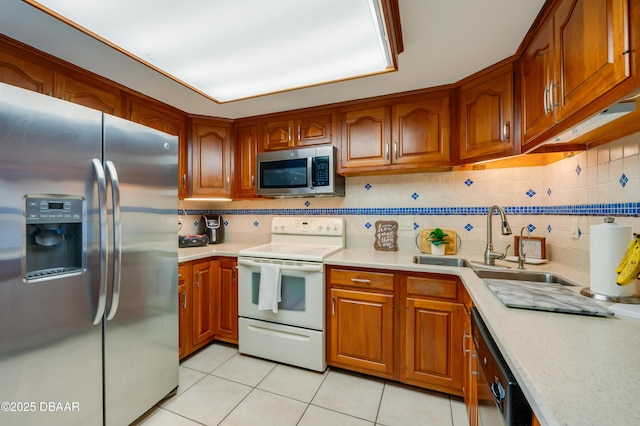 kitchen featuring a sink, brown cabinets, appliances with stainless steel finishes, and light countertops