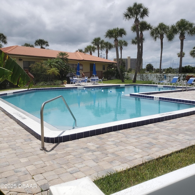 pool with a patio area and fence