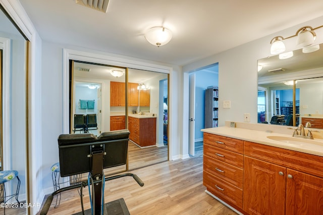 bathroom with vanity, wood finished floors, visible vents, and baseboards