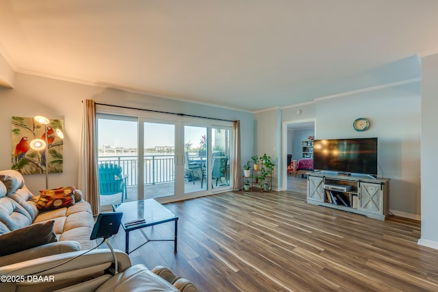 living area featuring french doors, baseboards, wood finished floors, and crown molding