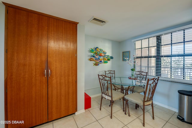 dining room with light tile patterned floors, visible vents, and baseboards