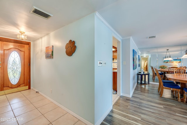 foyer entrance featuring light wood-type flooring, visible vents, and baseboards