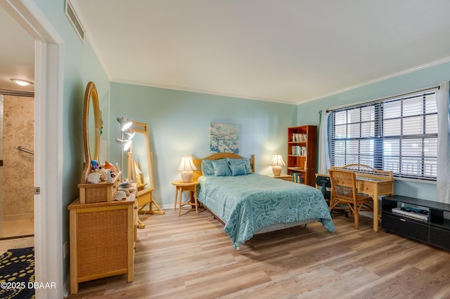 bedroom with visible vents, wood finished floors, baseboards, and ornamental molding