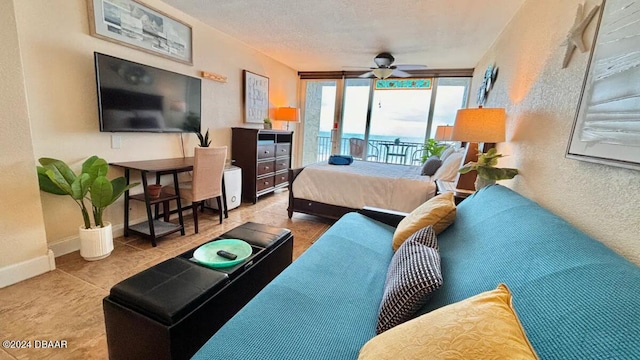 tiled bedroom featuring access to outside, ceiling fan, and a textured ceiling