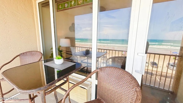 balcony with a water view and a beach view