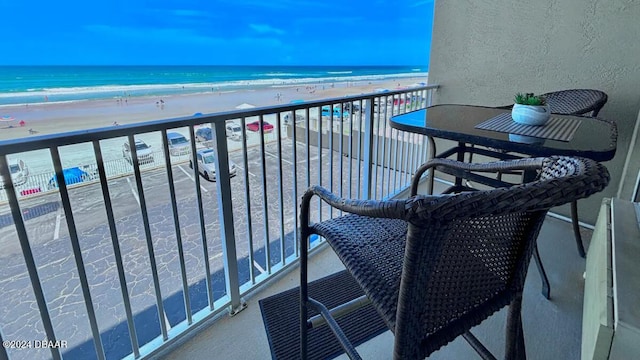 balcony featuring a beach view and a water view