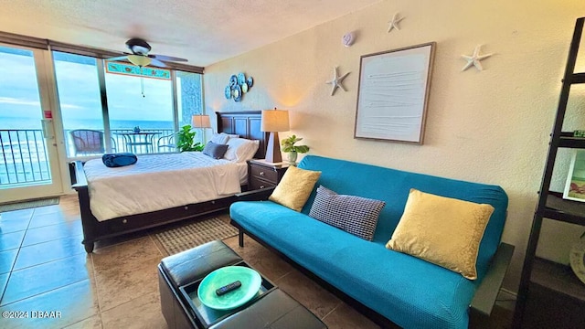 tiled bedroom featuring access to exterior, a textured ceiling, and ceiling fan