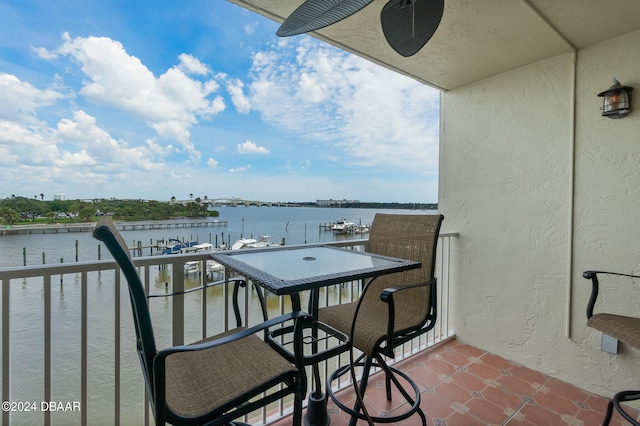 balcony with a water view and ceiling fan