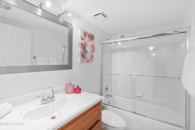 full bathroom with vanity, toilet, and bath / shower combo with glass door