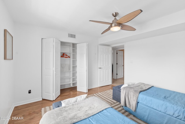 bedroom with hardwood / wood-style flooring, ceiling fan, and a closet