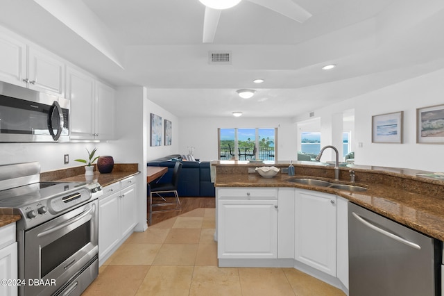 kitchen with sink, white cabinets, dark stone counters, and appliances with stainless steel finishes