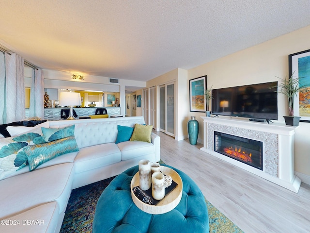 living room with a textured ceiling and light hardwood / wood-style flooring