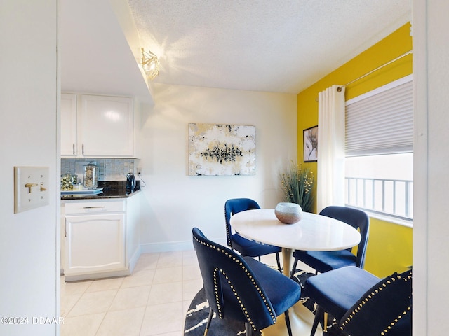 tiled dining room featuring a textured ceiling