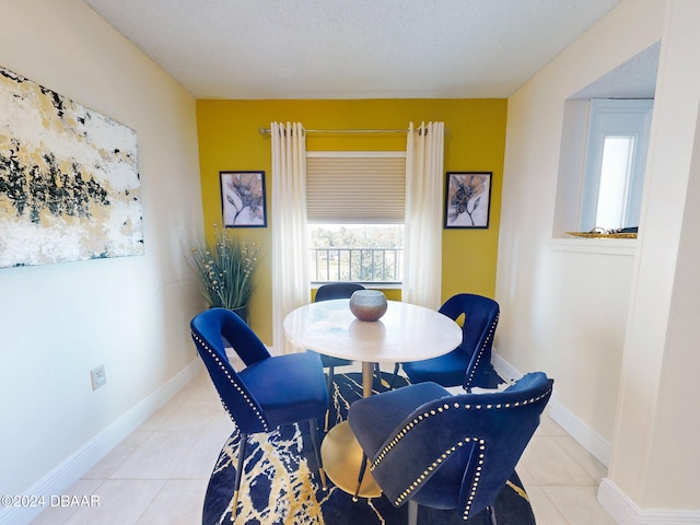 tiled dining room featuring a textured ceiling