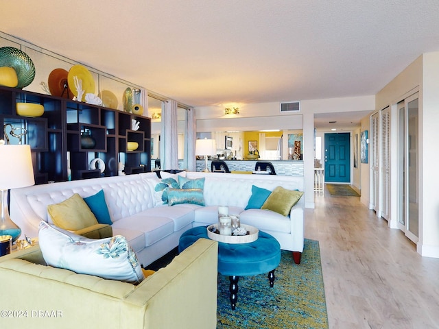 living room featuring wood-type flooring and a textured ceiling