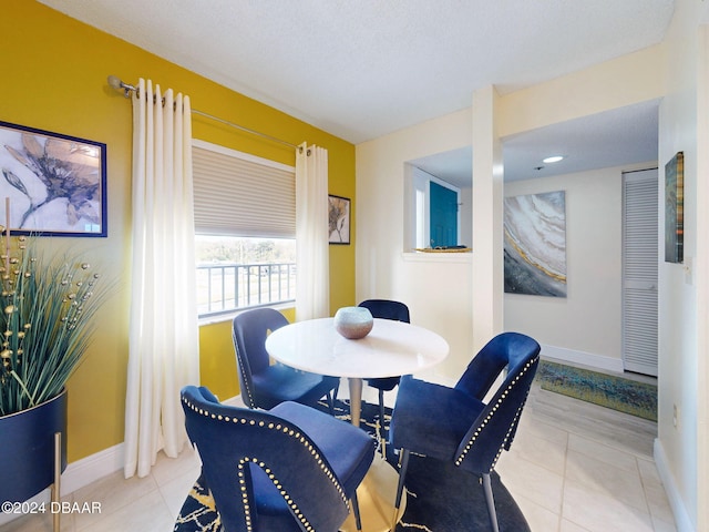 dining area with light tile patterned floors and a textured ceiling