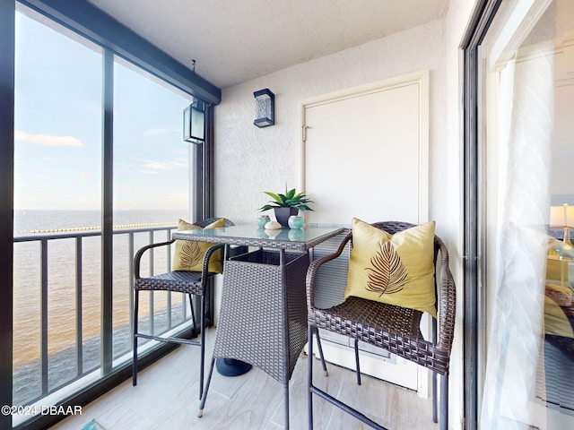 sunroom / solarium featuring a healthy amount of sunlight and a water view