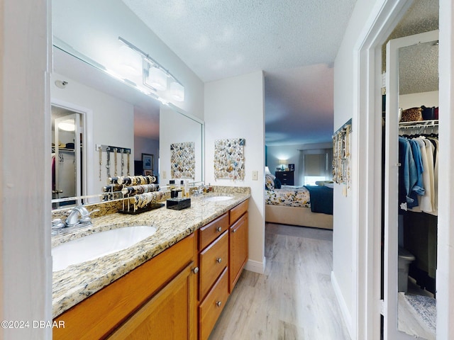 bathroom featuring vanity, wood-type flooring, and a textured ceiling