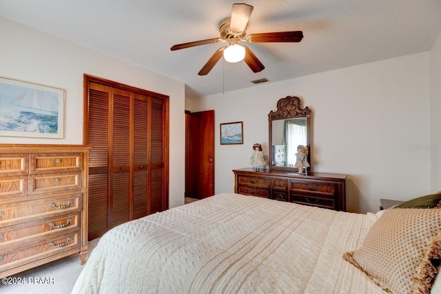 bedroom featuring carpet flooring, a textured ceiling, ceiling fan, and a closet