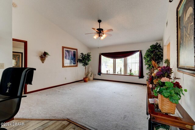 interior space with hardwood / wood-style floors, ceiling fan, a textured ceiling, and lofted ceiling