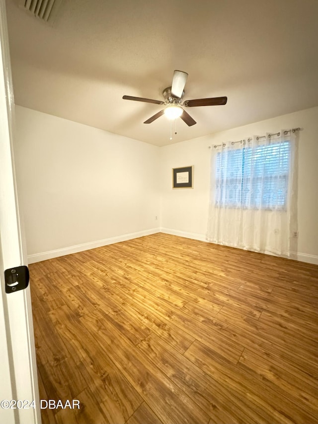 spare room with hardwood / wood-style floors and ceiling fan