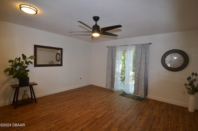 empty room with ceiling fan, a textured ceiling, and dark hardwood / wood-style floors