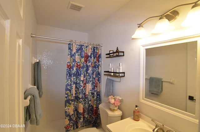 bathroom featuring a shower with curtain, vanity, and toilet