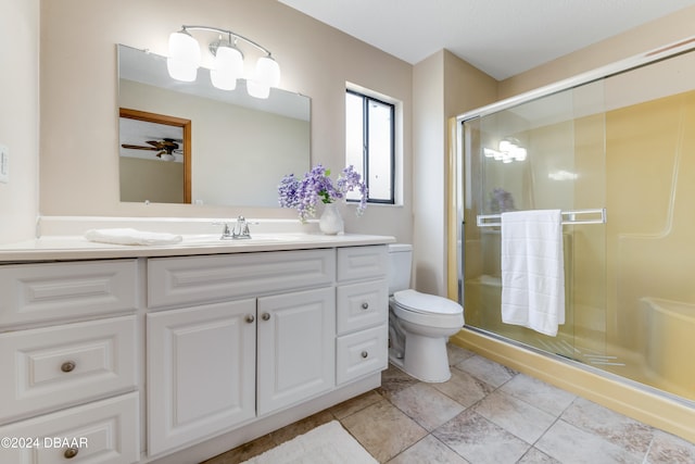 bathroom featuring toilet, vanity, and a shower with door