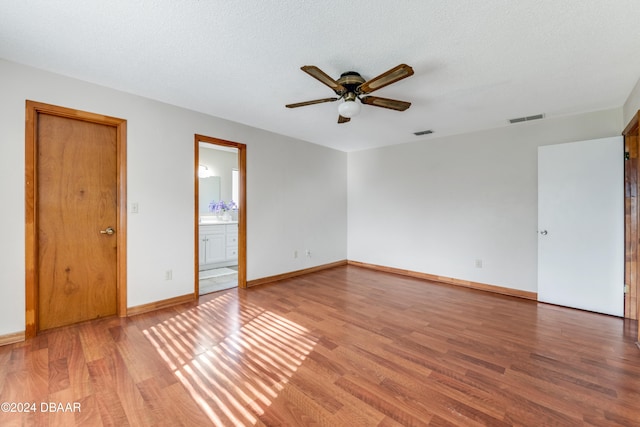 unfurnished room with wood-type flooring, ceiling fan, and a textured ceiling