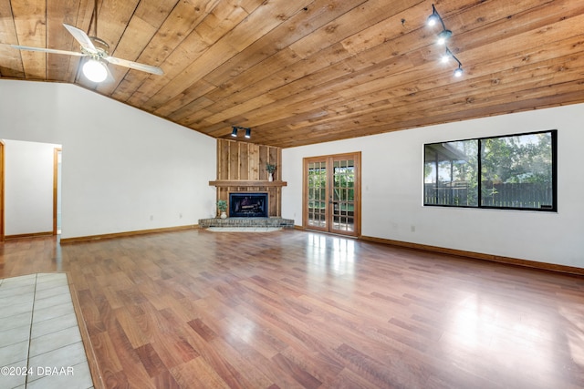 unfurnished living room with lofted ceiling, track lighting, wooden ceiling, and light hardwood / wood-style floors