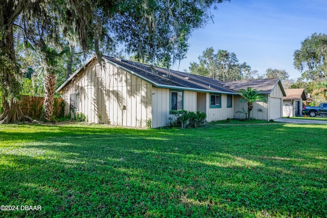 view of side of property with a lawn and a garage