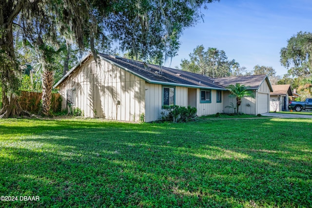 500 Sandy Oaks Blvd, Ormond Beach, FL 32174 - view of home's exterior with a garage, a yard, board and batten siding, and driveway