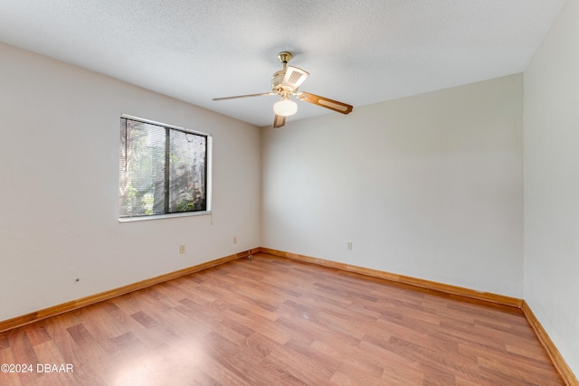 spare room with light wood-type flooring, a textured ceiling, and ceiling fan