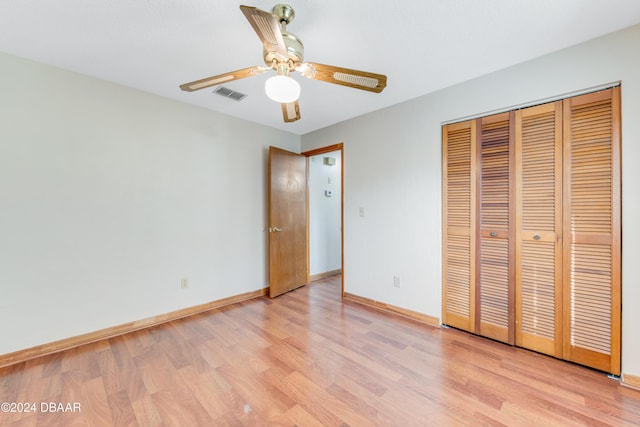 unfurnished bedroom with ceiling fan, a closet, and light wood-type flooring