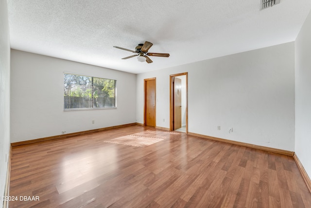 spare room with ceiling fan, a textured ceiling, and light hardwood / wood-style floors