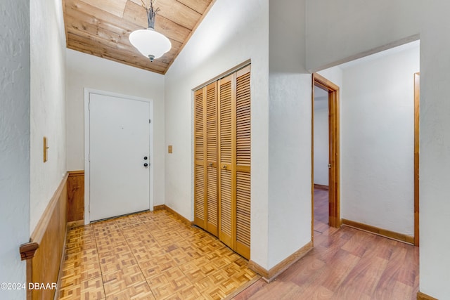 entrance foyer featuring light parquet flooring, vaulted ceiling, and wooden ceiling