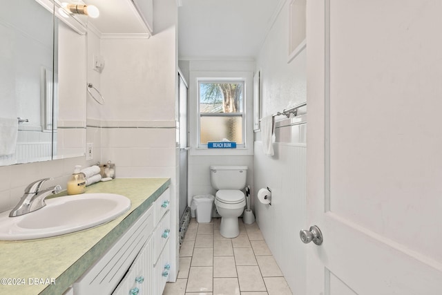 bathroom with tile walls, ornamental molding, vanity, tile patterned flooring, and toilet