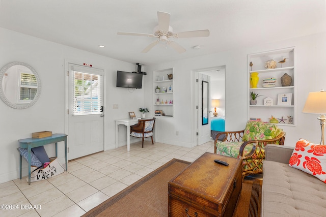 living room with built in features, light tile patterned floors, and ceiling fan