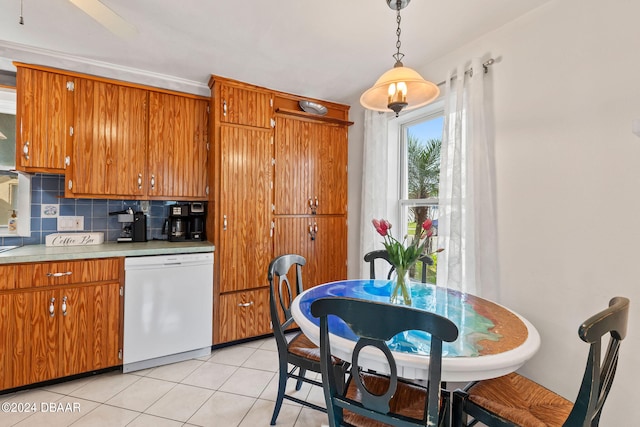 kitchen featuring decorative backsplash, hanging light fixtures, light tile patterned floors, and white dishwasher