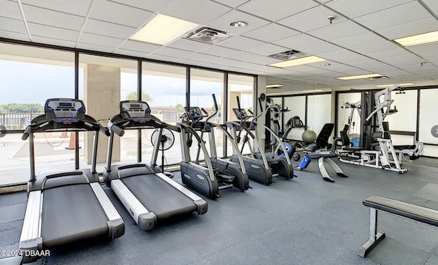 gym with a paneled ceiling and floor to ceiling windows