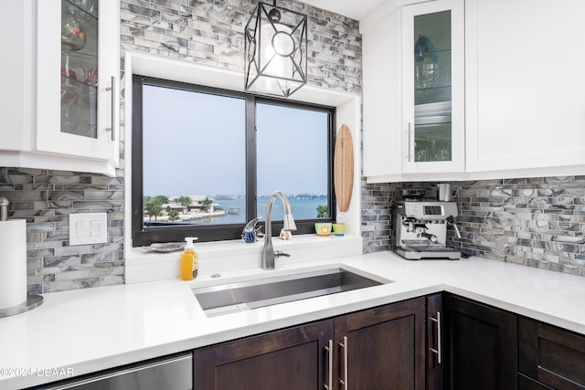 kitchen with backsplash, white cabinets, dark brown cabinetry, and sink