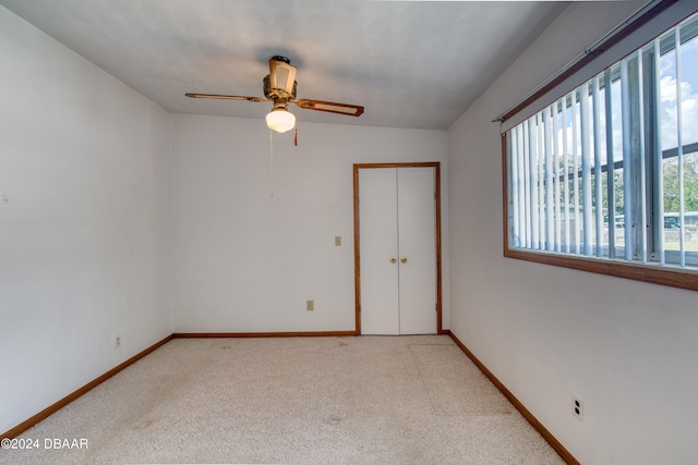 carpeted spare room with ceiling fan