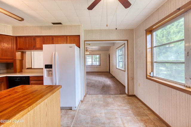 kitchen featuring dishwasher, white refrigerator with ice dispenser, and wooden counters