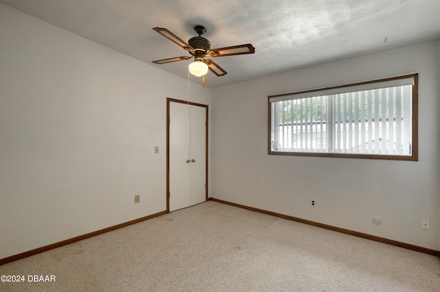 unfurnished room with light colored carpet and ceiling fan