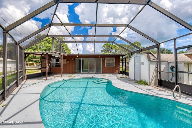 view of swimming pool featuring glass enclosure, a patio, and a shed