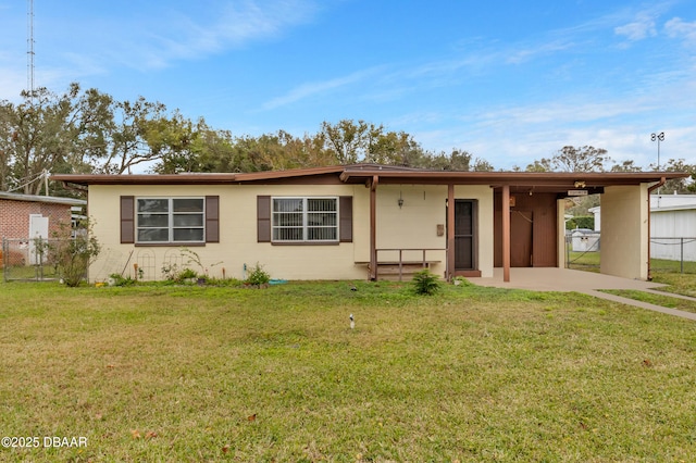 ranch-style house featuring a front lawn and a carport