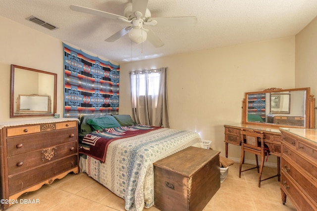 bedroom featuring a textured ceiling, ceiling fan, and light tile patterned flooring