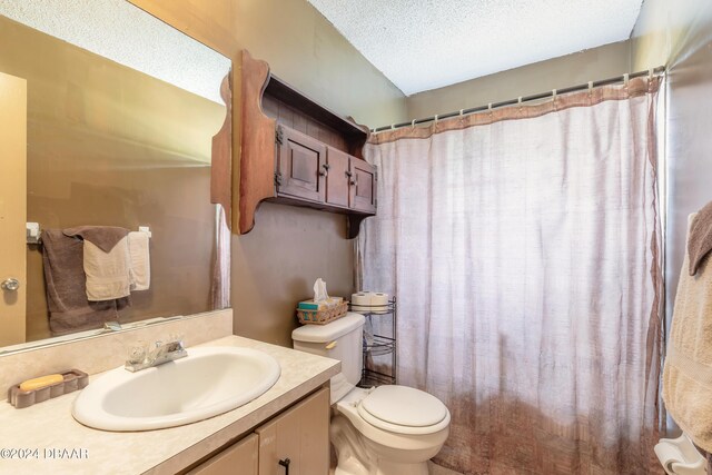 bathroom with a shower with shower curtain, a textured ceiling, vanity, and toilet