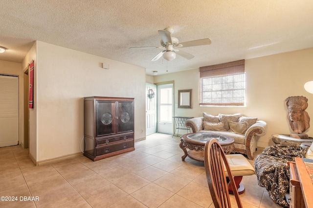 tiled living room with ceiling fan and a textured ceiling