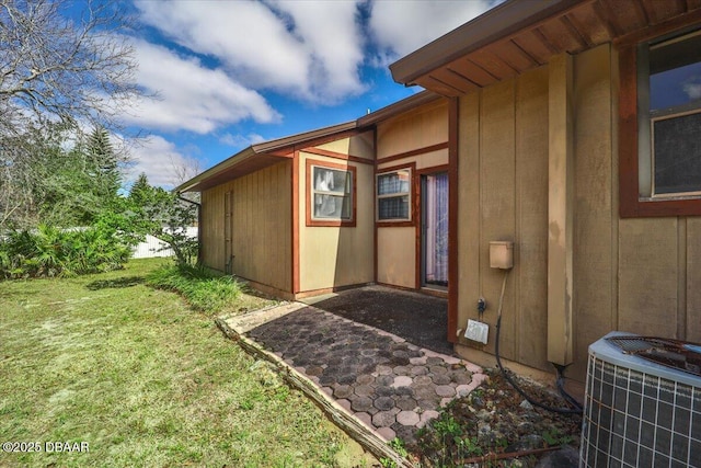 view of side of property with a lawn and central air condition unit